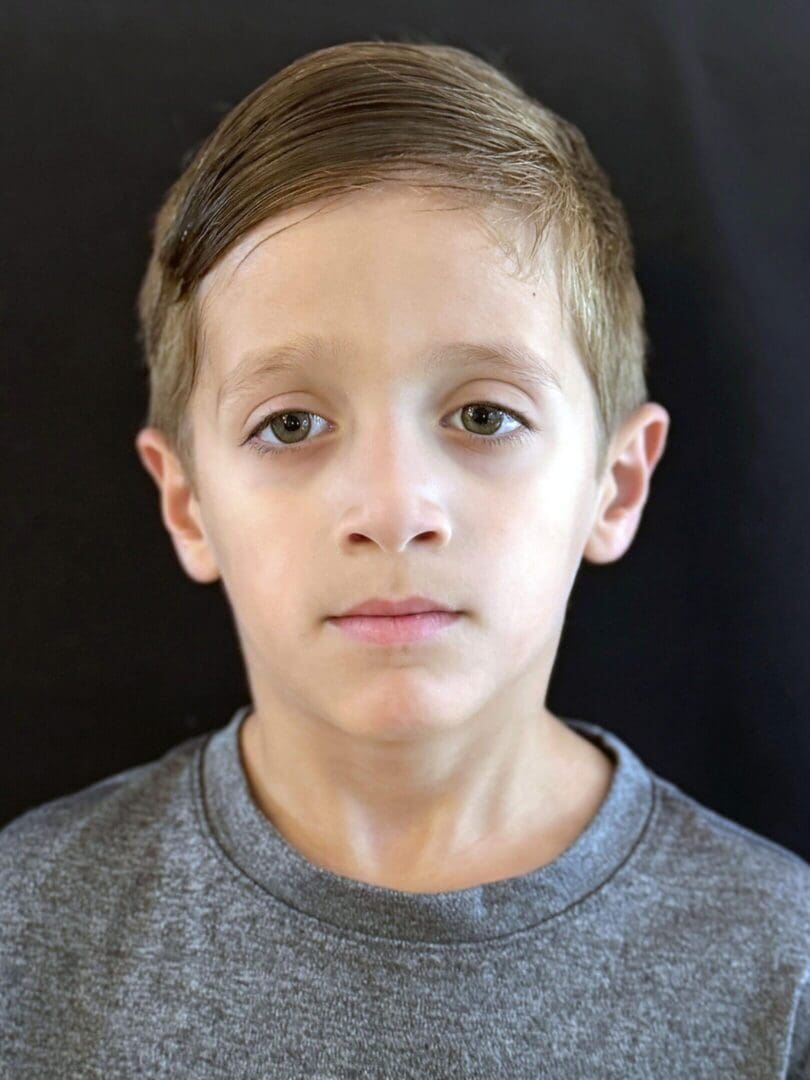 Portrait of a young boy with short hair and a neutral expression.
